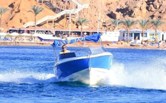 Speedboat cruising along Sharm El Sheikh shoreline with coastal view in background.