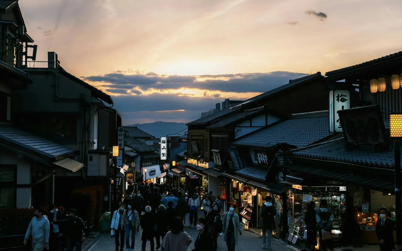 Crowded street in Kyoto's Higashiyama district at sunset during a self-guided audio walking tour.
