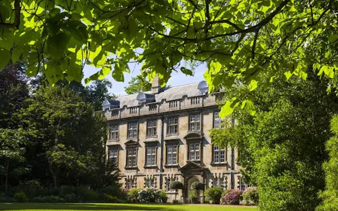 Cambridge historic building surrounded by lush greenery on self-guided city exploration game.