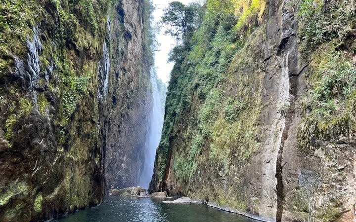 Dragon Waterfall between lush cliffs on Sapa motorbike tour route.
