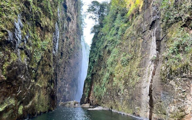 Dragon Waterfall between lush cliffs on Sapa motorbike tour route.