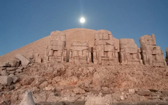 Ancient stone statues at Mount Nemrut, Turkey, under a clear sky.