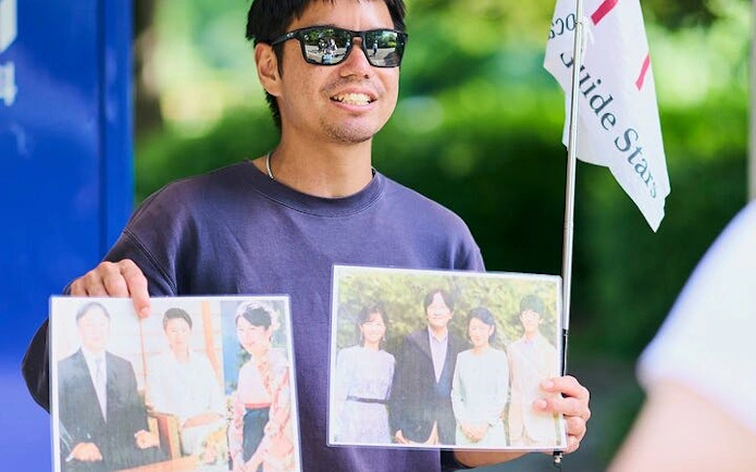 Guide holding photos during Tokyo Castle and Imperial Palace walking tour.