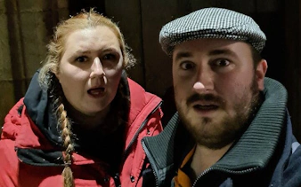 Two people exploring Glasgow at night during a self-guided ghost tour game.