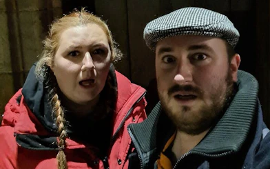 Two people exploring Glasgow at night during a self-guided ghost tour game.