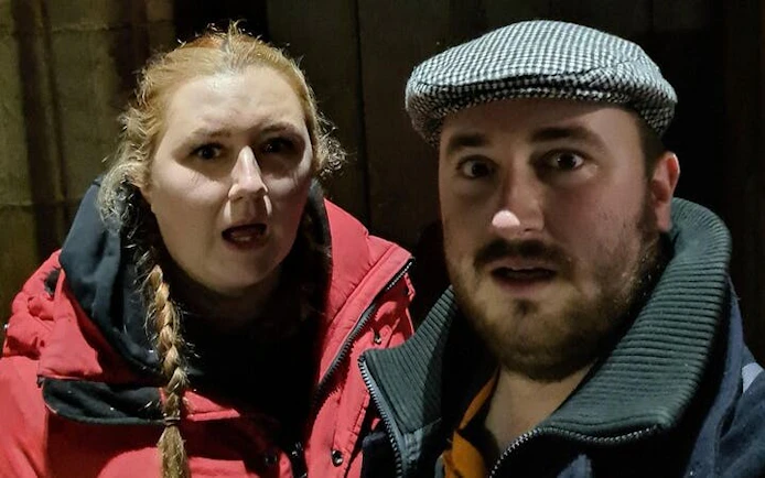 Two people exploring Glasgow at night during a self-guided ghost tour game.
