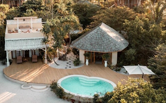 Luxury beachfront villa with private pool in Zanzibar, surrounded by lush greenery.
