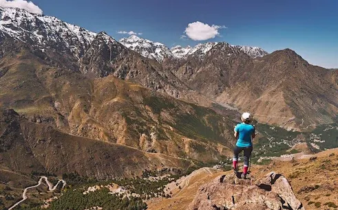 Hiker overlooking Atlas Mountains landscape near Marrakesh.