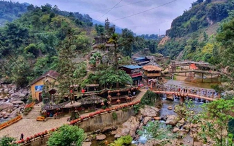Sapa Cat Cat Village with traditional houses and scenic bridge over a stream.
