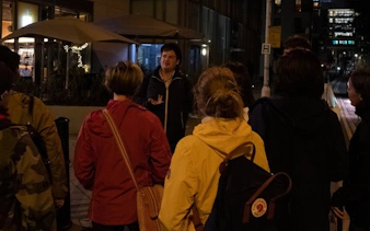 Group listening to guide during Little Venice ghost walk at night.