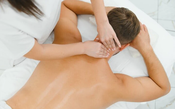 Man receiving a back massage at a luxury Moroccan hammam in Marrakesh.