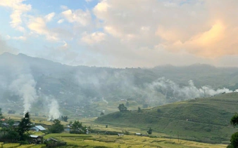 Sapa valley landscape with misty hills and rice terraces at sunset, Vietnam.