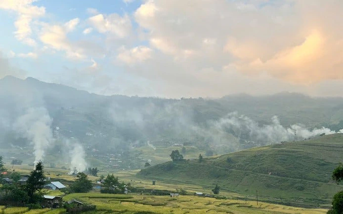 Sapa valley landscape with misty hills and rice terraces at sunset, Vietnam.