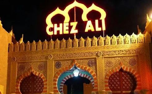 Chez Ali entrance illuminated at night, Marrakesh folklore show location.