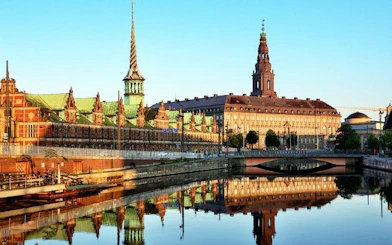 Copenhagen cityscape with Christiansborg Palace reflected in canal, part of self-guided walking tour.