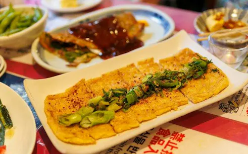 Tofu dish garnished with green onions at Kyoto Nishiki Market food tour.