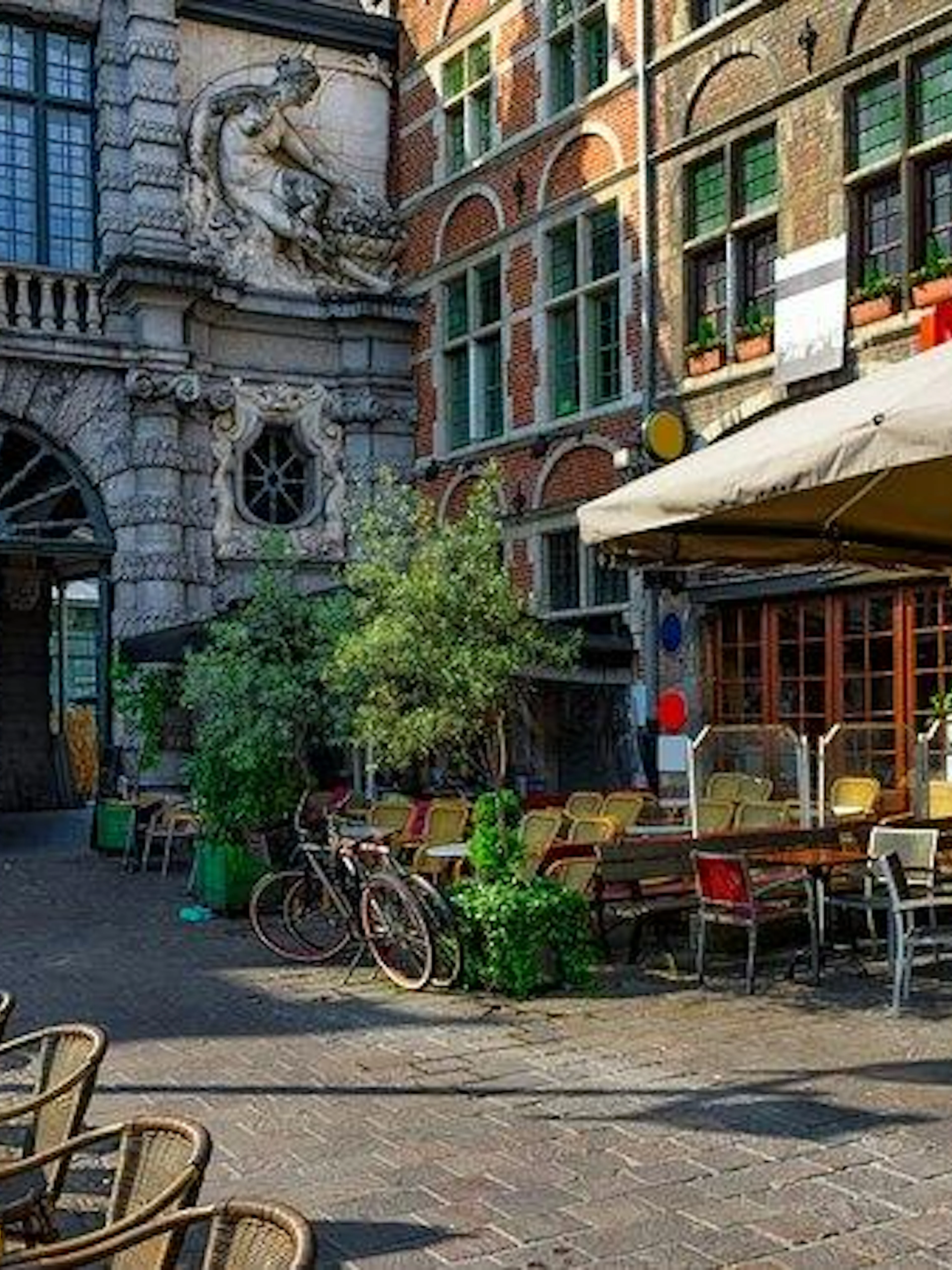 Outdoor café seating in Bruges near historical architecture, part of Bruges and Ghent day trip from Brussels.