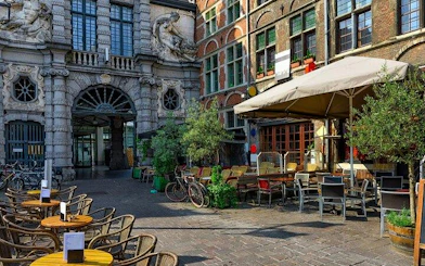 Outdoor café seating in Bruges near historical architecture, part of Bruges and Ghent day trip from Brussels.