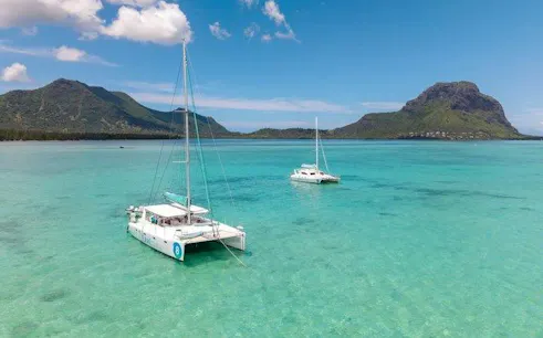 Catamarans sailing near Le Morne Brabant, Mauritius, with turquoise waters and mountain views.