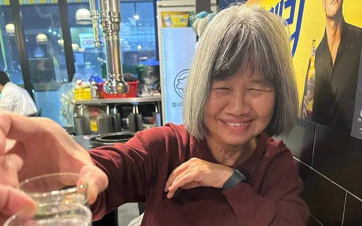 Person enjoying Korean BBQ dinner in a Seoul restaurant during Gangnam walking tour.