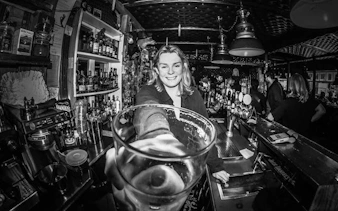 Bartender serving a drink at a local bar in Reykjavík during a guided bar crawl tour.
