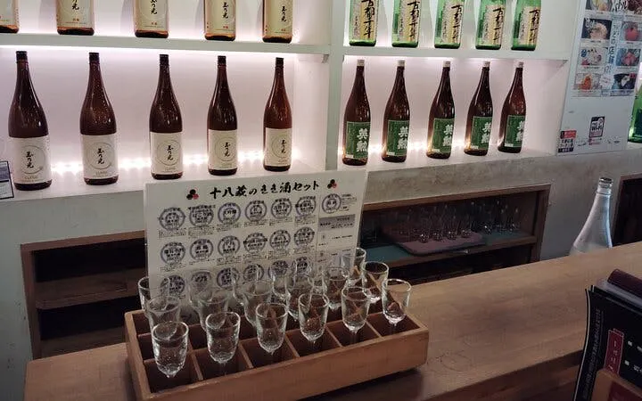 Sake bottles and tasting glasses at a Kyoto brewery tour.