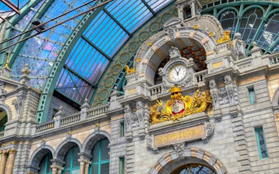 Antwerp Central Station facade with clock and ornate architecture on self-guided walking tour.