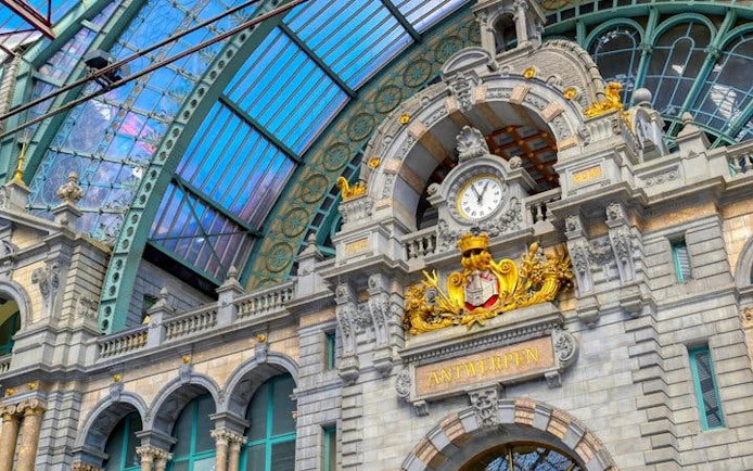 Antwerp Central Station facade with clock and ornate architecture on self-guided walking tour.