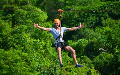 Ziplining through lush forest in Punta Cana adventure tour.