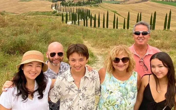 Group enjoying scenic view of Val d'Orcia's cypress-lined road during a tour from Florence.