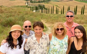 Group enjoying scenic view of Val d'Orcia's cypress-lined road during a tour from Florence.