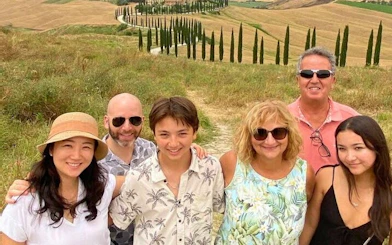 Group enjoying scenic view of Val d'Orcia's cypress-lined road during a tour from Florence.