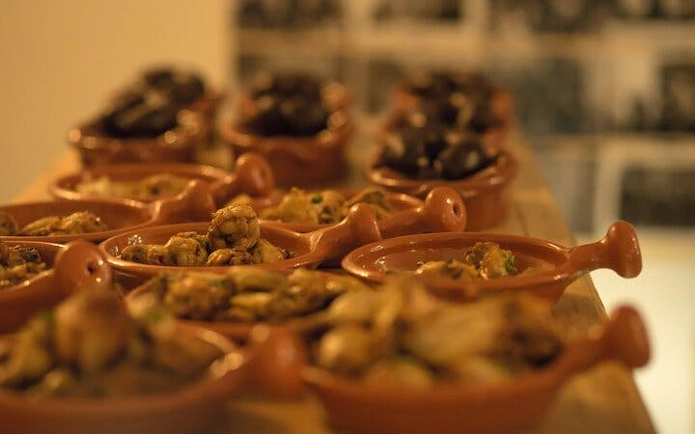 Traditional Portuguese dishes served in clay pots at a Lisbon Roman theatre venue.
