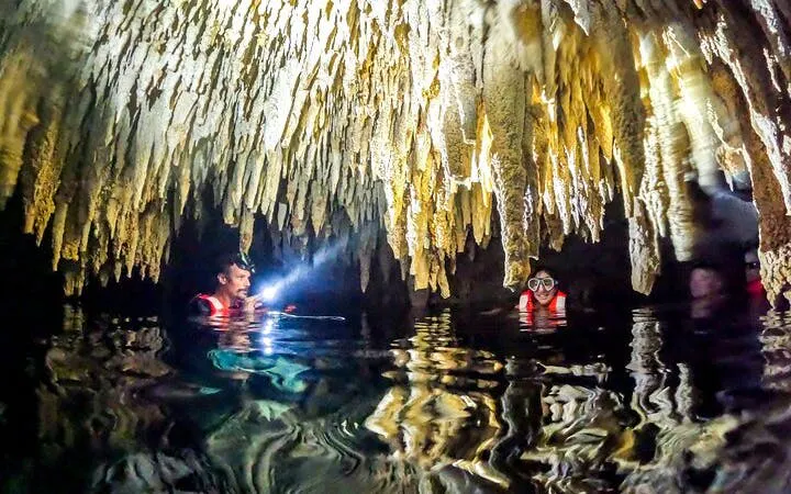 Cenote cave swim with guide and snorkeler in Akumal, Mexico.