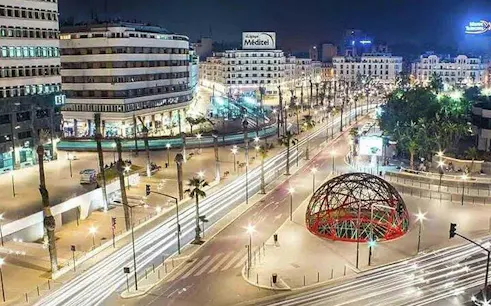 Casablanca cityscape at night with illuminated streets and modern architecture.