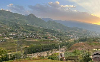 Sapa rice fields and villages with mountain backdrop during motorbike tour.