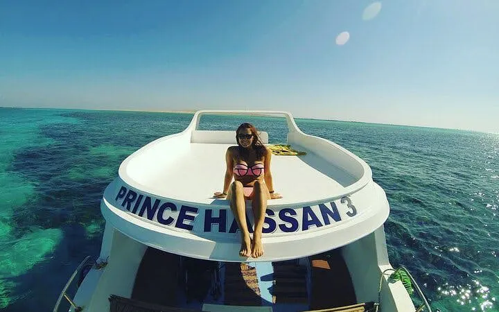 Glass boat tour on clear waters, Sharm El Sheikh, with passenger enjoying the view.