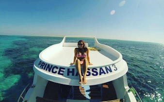 Glass boat tour on clear waters, Sharm El Sheikh, with passenger enjoying the view.