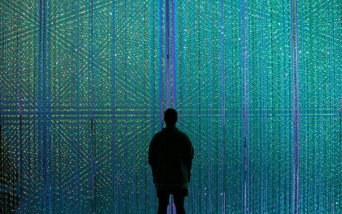Silhouette of a person in front of digital light display at teamLab Borderless, Tokyo.
