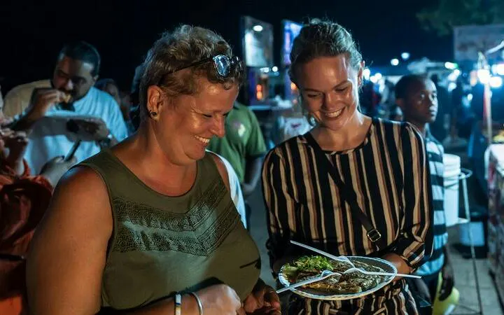 Tourists enjoying local cuisine at Stone Town Zanzibar night food market.