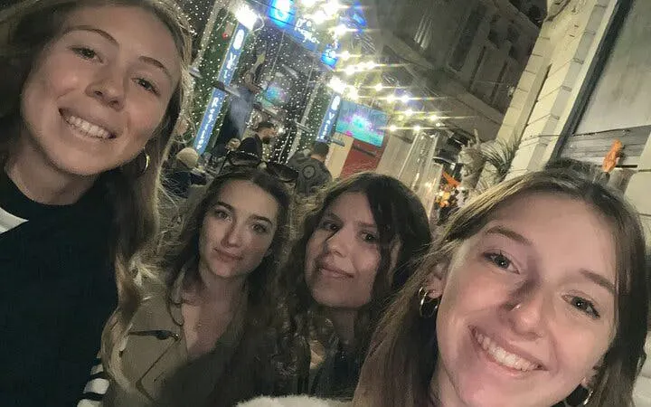 Group of friends exploring a lively street in Old Town Bucharest at night.