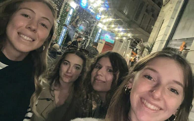 Group of friends exploring a lively street in Old Town Bucharest at night.