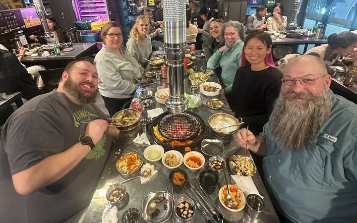 Small group enjoying Korean BBQ dinner in Gangnam, Seoul during walking tour.