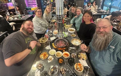 Small group enjoying Korean BBQ dinner in Gangnam, Seoul during walking tour.
