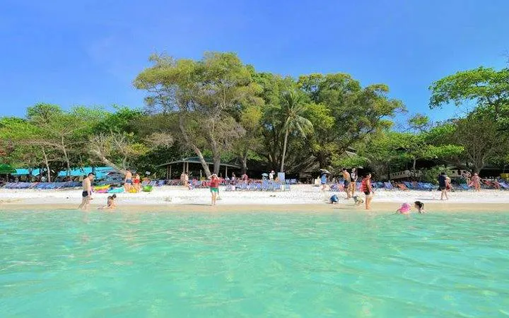 Tourists enjoying the beach and clear waters on Coral Island, Phuket.