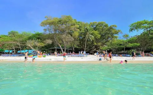 Tourists enjoying the beach and clear waters on Coral Island, Phuket.
