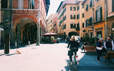Street scene in Pisa with cyclist and historic buildings near Leaning Tower tour.