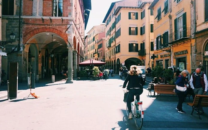 Street scene in Pisa with cyclist and historic buildings near Leaning Tower tour.