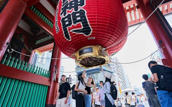 Visitors under the large red lantern at Kaminarimon Gate, Senso-ji Temple, Tokyo.