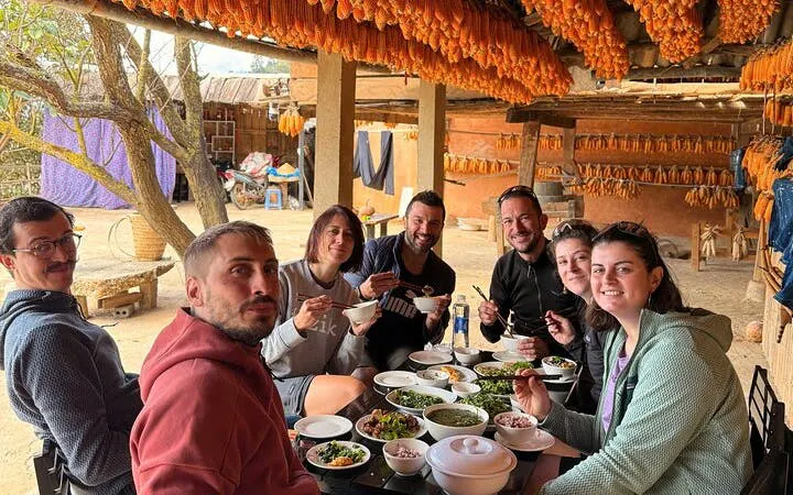 Group enjoying traditional meal during private car tour from Sapa to Mu Cang Chai rice terraces.